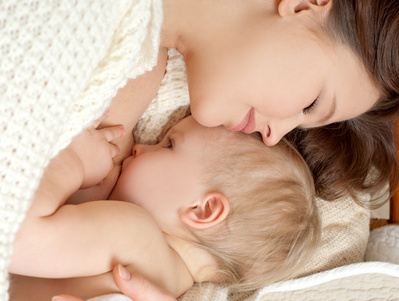 妈妈抱着宝宝进行母乳喂养，这样的时刻令人动容，母爱在我们身边静静地流淌着……