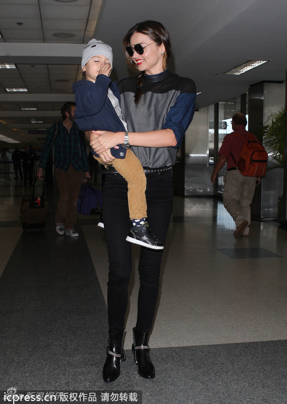 美国洛杉矶当地时间2013年11月20日，米兰达-可儿抱爱子小佛林现身机场。小佛林不畏惧镜头，甚至对镜头抛媚眼，很可爱。