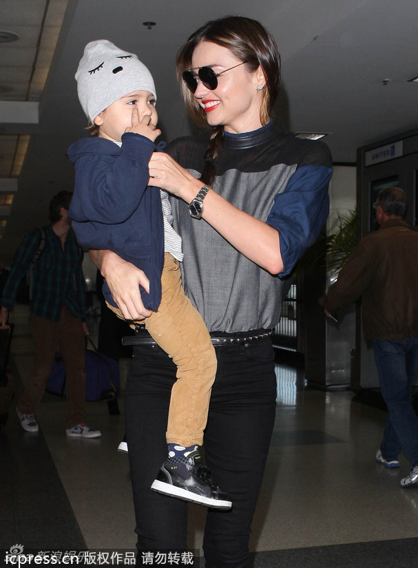 美国洛杉矶当地时间2013年11月20日，米兰达-可儿抱爱子小佛林现身机场。小佛林不畏惧镜头，甚至对镜头抛媚眼，很可爱。