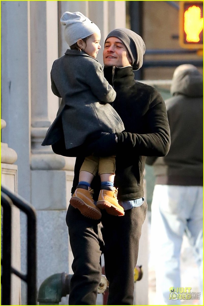 当地时间12月16日，纽约，好莱坞明星奥兰多·布鲁姆(Orlando Bloom)带着儿子弗林(Flynn)出门，他将弗林放在肩头，活泼的小家伙看到镜头调皮吐舌，在爸爸怀里开心大笑。