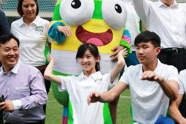 2013年5月19日，江苏南京，2014南京青奥会前瞻，志愿者代表“奶茶妹妹”章泽天手捧吉祥物“砳砳”接受访问。