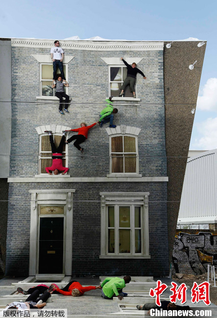 伦敦民众体验超现实“房屋” 轻松“飞檐走壁” 当地时间2013年6月25日，英国伦敦，游客们在艺术作品上摆出各种造型，仿佛“飞檐走壁”一般。只要巧妙地组合使用和控制好镜子的反射角度，能够形成很多令人惊叹的效果。阿根廷艺术家Leandro Erlich的现代艺术作品“Dalston House”就运用镜子来形成人错视觉的，在地上摆放了建筑立面模型，人在地上做各种造型，就能看到那些违反地球引力的各种视觉效果，这些都是通过四层楼高的多层镜子反射来实现的。