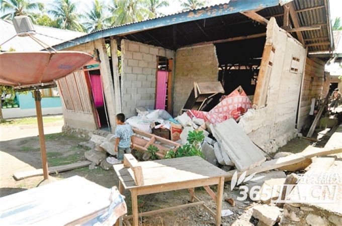 8月19日，在印度尼西亚苏拉威西省，一个孩子走过地震中受损的房屋。