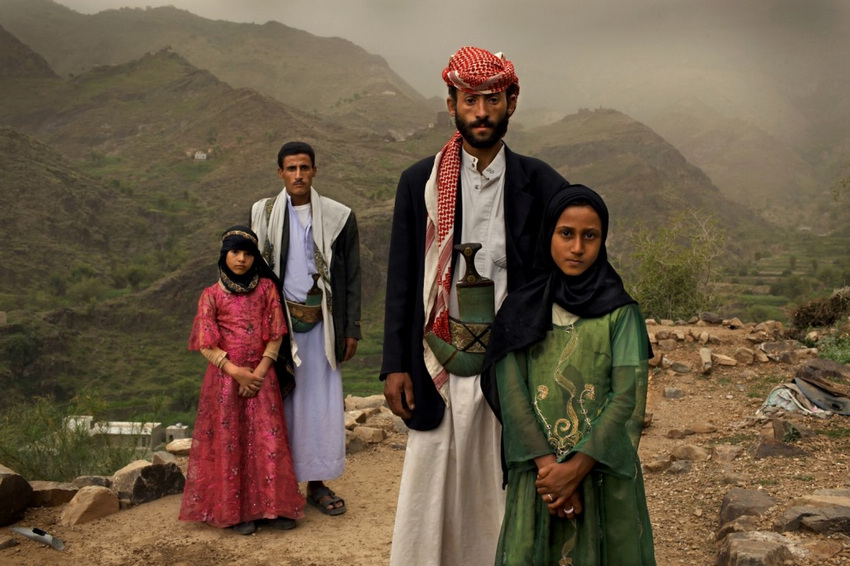 2011年6月10日，也门•哈杰省。Tahani(粉色衣服)与她的同学Ghada分别与自己的丈夫站在一起。起初时，Tahani一看到自己的丈夫就会到处躲藏，她在6岁时就嫁给了当时25岁的丈夫。而她的同学Ghada与她的命运一样，也是小新娘。