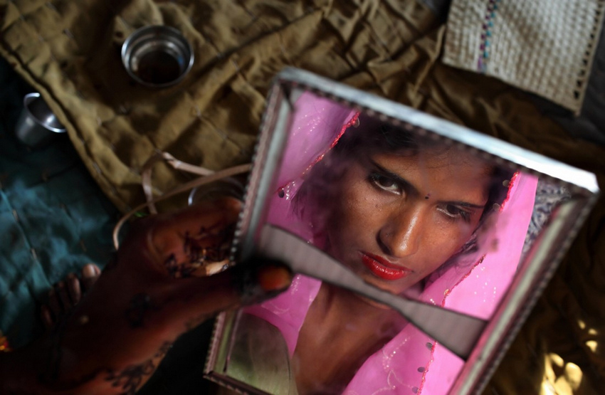 2010年4月26日，印度•新德里。Radha (15岁)在结婚前看着镜中的自己。她和两个妹妹Gora (13岁)、Rajni (5岁)在同一天嫁给了三兄弟。虽然印度法律禁止童婚，但这种行为还是为印度社会的很大一部分人所接受。