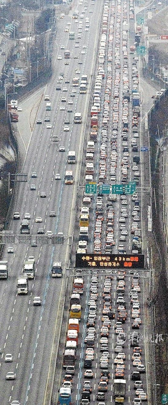 韩国釜山高速 韩国4000多万人口中，有大约2000万要回家乡过年。所以春节期间高速公路也异常堵塞。图为2010年2月12日，釜山高速公路上冒雪返家的车辆。