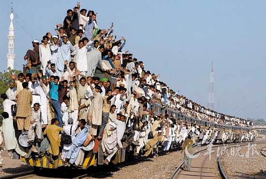 巴基斯坦坦木尔坦 2008年11月2日，巴基斯坦坦木尔坦，数十万逊尼派穆斯林参加宗教聚会后，乘火车返家。车顶和车厢周边都满是以各种高难度的动作和姿势搭乘火车的人，远远望去，乘客都像是在表演“杂技”，令人叹为观止。