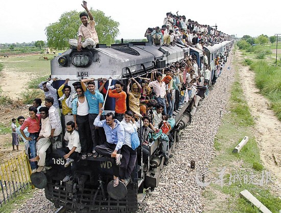 印度新德里 2010年7月24日，印度新德里，民众坐在火车顶上赶赴敬师节的庆祝活动。据统计，印度铁路每年运送旅客高达60亿人次。