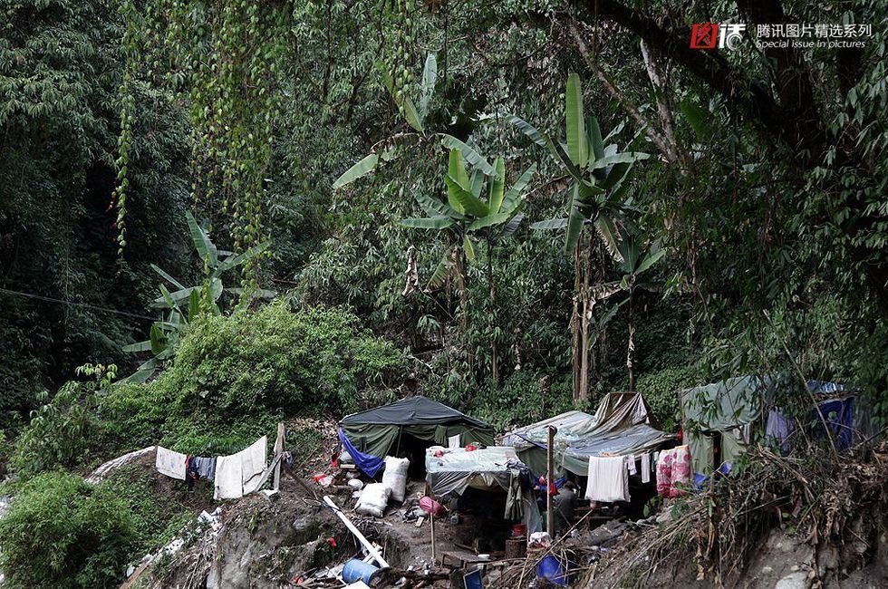 这些护路工人在悬崖峭壁和潮湿的丛林间搭起临时帐篷，支起几块木板，架起几口锅，就算有了吃住的地方。(田贺)