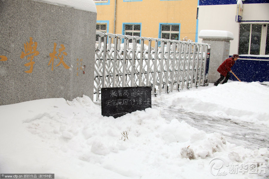 2013年11月18日，吉林省吉林市松江实验小学雪堆中插着停课通知的小黑板。