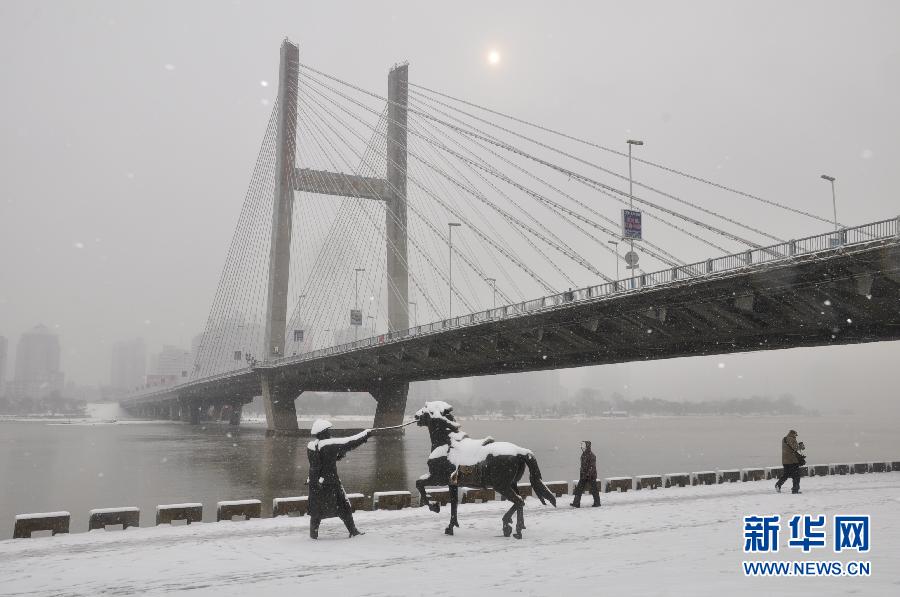 11月17日，行人冒雪行进在吉林省吉林市头道码头的街道上。 11月16日，吉林省多地遭遇今年入冬以来首场大雪。吉林省气象台继16日发布了道路冰雪橙色预警之后，又于17日6时发布暴雪橙色预警。吉林省气象局启动重大气象灾害(暴雪)III级应急响应，吉林省境内的京哈、珲乌等东北主要高速公路和长春龙嘉机场均受到影响。