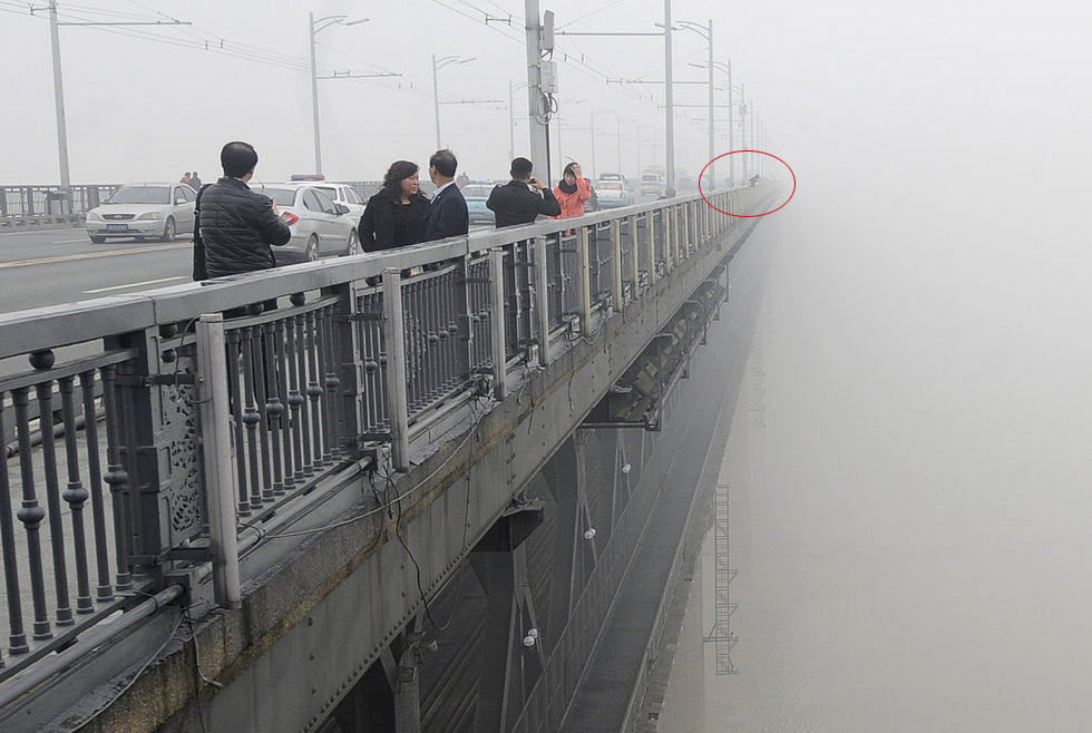 2月27日中午，武汉长江大桥上，两名年轻人先后翻越护栏坠入江中。至27日晚9时记者发稿时，两人仍下落不明。中午12时，记者在长江大桥武昌桥头堡处拍雾霾天气照片，突然有人呼喊“江面上有个人”。记者朝大桥下方看去，发现在距武昌江滩约百余米处，有一人在水中挣扎，时隐时现。就在这时，又有人爬上大桥护栏，一跃而下，记者根本来不及阻拦