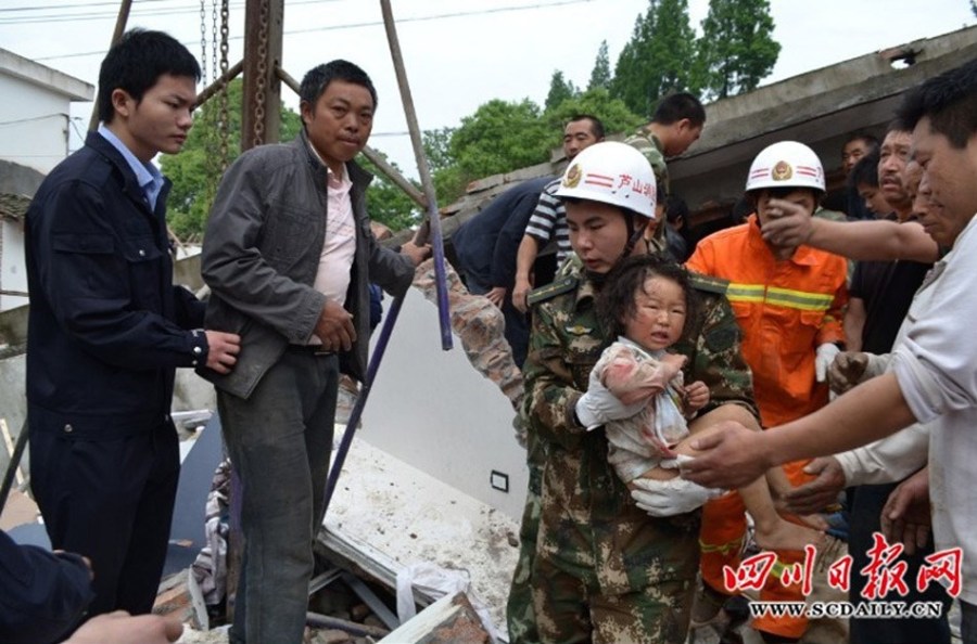 高清组图：四川芦山县地震灾区的孩子们 8点30分，芦山县金花路，消防官兵用手刨开砖石，抱出小女孩。