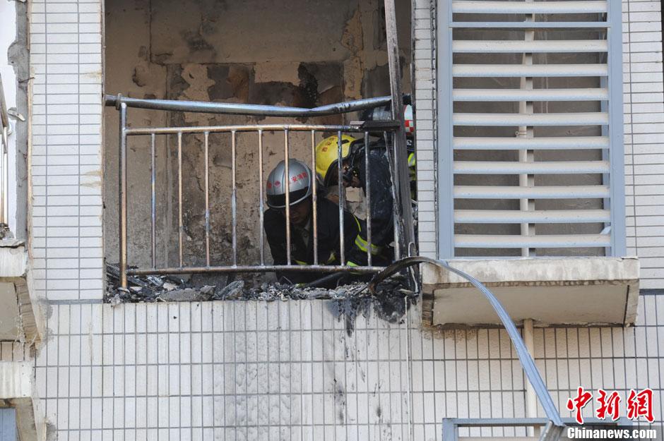 图为消防人员对爆炸现场进行清理。