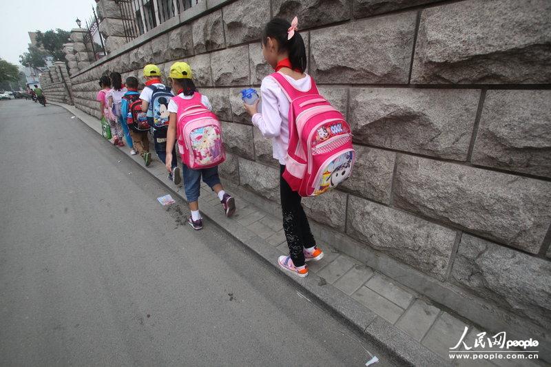 2013年09月11日，济南运署街上，小学生走史上“最窄人行道”上学。 济南市历下区运署街泉城中学对面的人行道，宽度仅约20厘米，仅能勉强通过一人，被附近居民戏称为“史上最窄人行道”。 2013年09月11日，济南运署街上，小学生走史上“最窄人行道”上学。