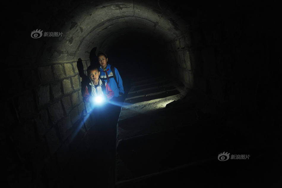 2013年5月29日，乌鲁木齐水磨沟区涝坝沟村，8岁的巴特尔汗通过一条长700米的隧道上学。这条隧道是村子通往外界最快的一条路，巴特尔汗自己走得花25分钟左右，而如果走大路就得花1个多小时才能从山里面绕出去。