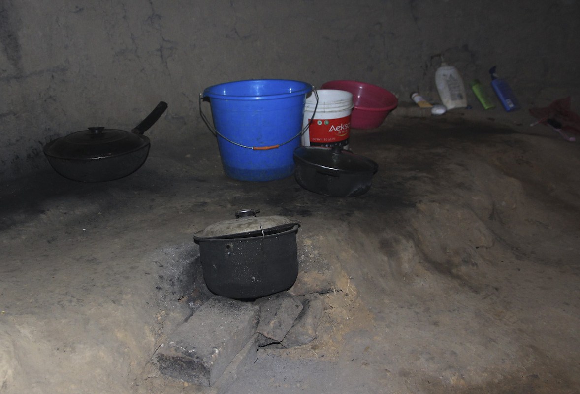 2013年9月16日，河南省郑州市，老张的住所，正对砖窑口的洞壁下，摆着几张捡来的小木桌和方凳，地面上，摆着洗净的锅碗瓢盆。