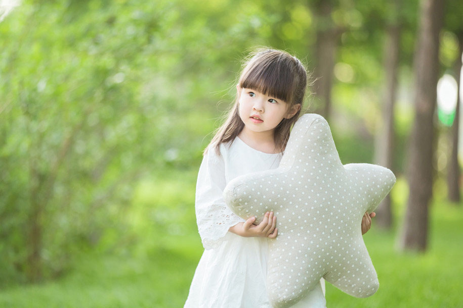 一位可爱的白裙子小女孩站立在草地上,清新美好的画面超级的养眼