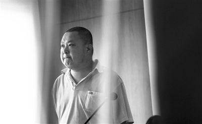 被告人紧闭双唇眼中含泪站在法庭上。昨日，廖丹因涉嫌诈骗罪在法院受审，后获准回家照顾妻子。新京报记者 王贵彬 摄