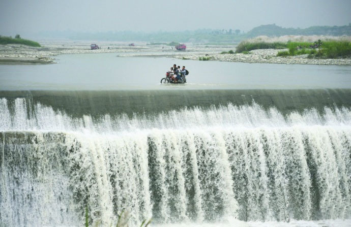 成都村民骑车来往拦河坝如临瀑布 画面很危险!