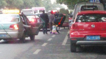 老人拖婴儿车带孩子穿行机动车道 网友惊出冷汗