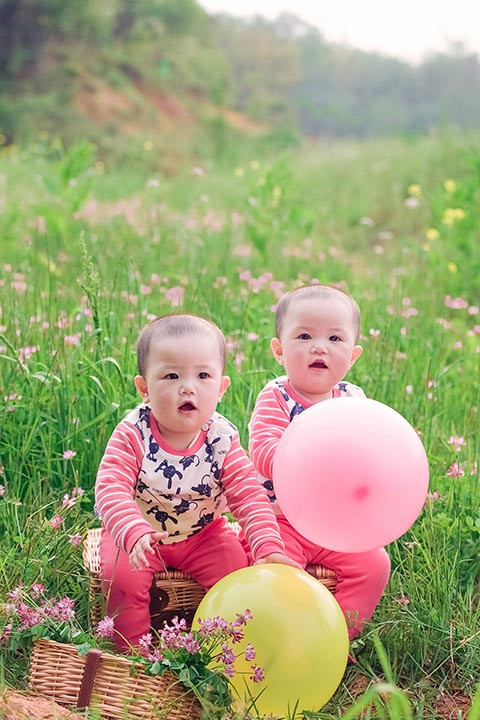 绿色草地里的双胞胎图片，两个人很是相似哟，小编傻傻分不清。生了一对双胞胎相信一定是件非常开心的事情，看着小宝宝慢慢长大，可爱迷人的样子无比的萌哟~~如此小宝宝你看着喜欢么~~