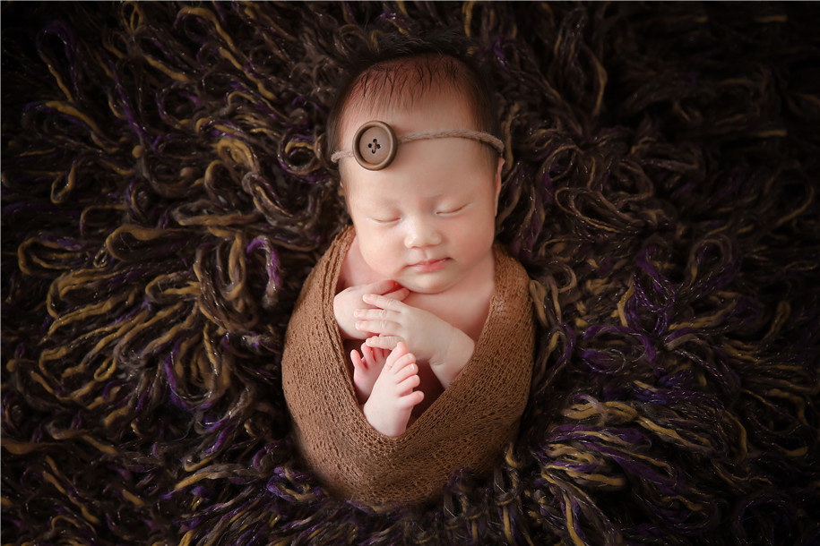 看到如此可爱的小宝宝图片了么，软萌软萌的小身子蜷缩着，闭着眼睛睡觉的样子超级的可爱哟，可爱十足的小婴儿看着超级的喜欢啊。加上小婴儿一些独特的道具，如此新生儿宝宝，乖萌十足呢。