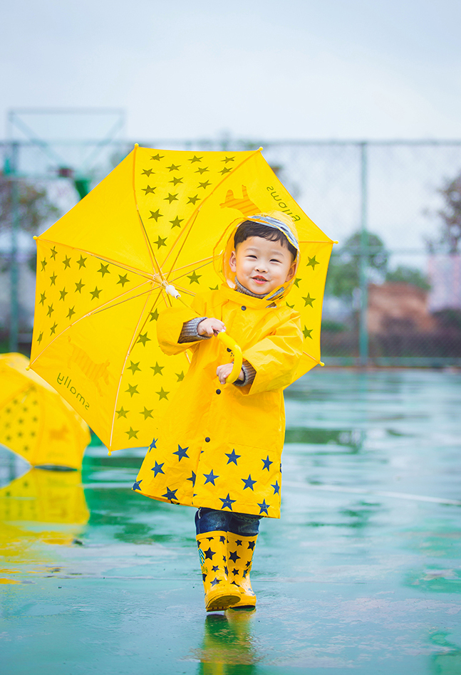 一身黄色雨衣的小萌娃超级的潮哟，撑着黄色的伞的他无比的可爱呢，笑起来小酒窝无比的迷人呢，雨天在篮球场淌水的他小编看了无敌的萌哟。如此可爱的小萌娃你看醉了么~~