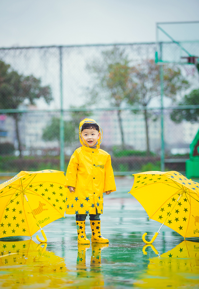 一身黄色雨衣的小萌娃超级的潮哟，撑着黄色的伞的他无比的可爱呢，笑起来小酒窝无比的迷人呢，雨天在篮球场淌水的他小编看了无敌的萌哟。如此可爱的小萌娃你看醉了么~~
