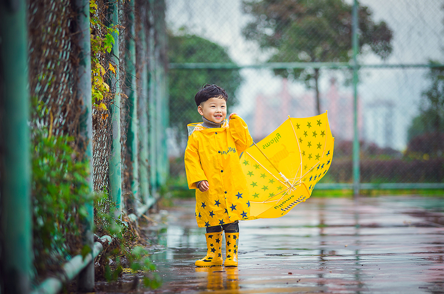 一身黄色雨衣的小萌娃超级的潮哟，撑着黄色的伞的他无比的可爱呢，笑起来小酒窝无比的迷人呢，雨天在篮球场淌水的他小编看了无敌的萌哟。如此可爱的小萌娃你看醉了么~~