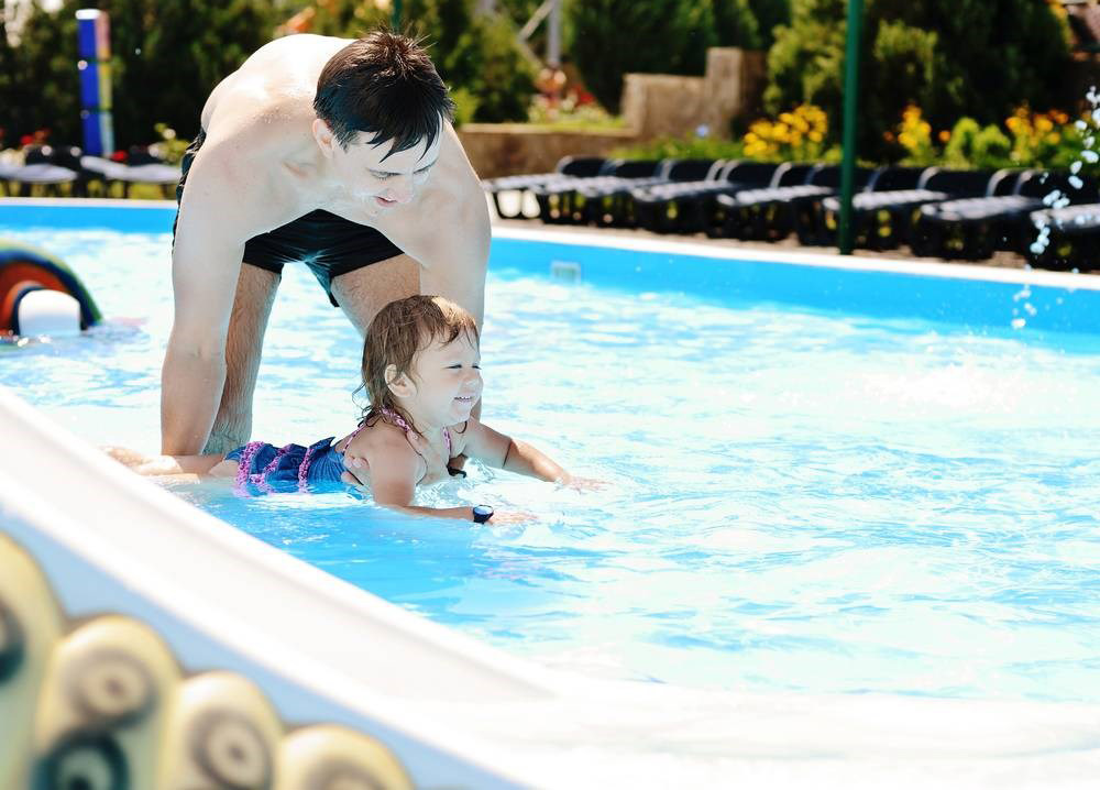 老爸跟孩子泳池玩耍的画面在夏天可是并不少见啊。清澈的水池旁，爸爸抱起儿子，超级有爱的画面无比的赞呢。帅气的爸爸跟萌娃同框也是一道亮丽的风景线啊~~
