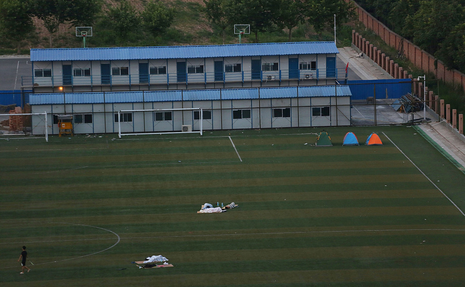 太热没空调 大学生在露天足球场睡觉