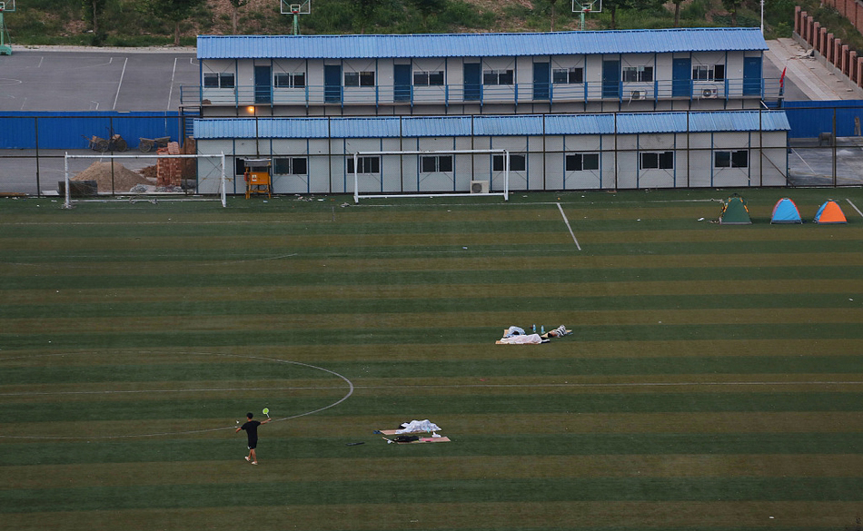 太热没空调 大学生在露天足球场睡觉