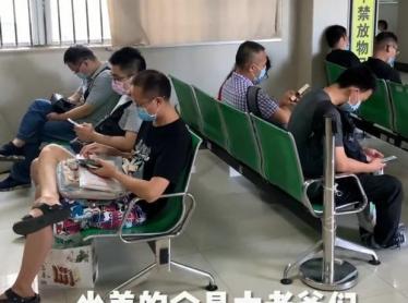 孕妇大着肚子排队产检，丈夫在椅子上玩手机，画面让人“唏嘘”